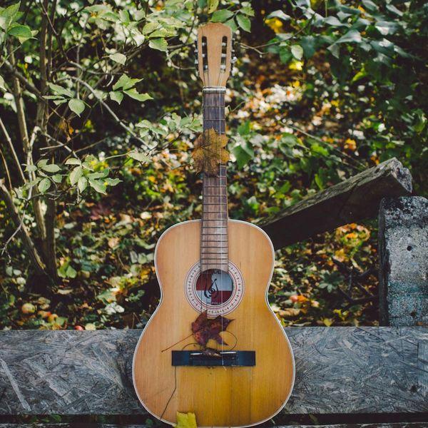 Akustikgitarre auf einer Steinbank im Freien