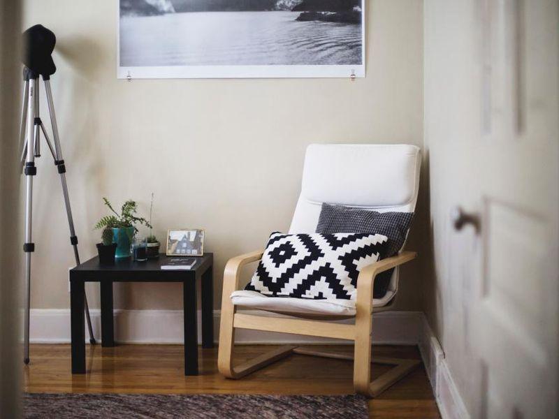 Light wooden armchair with a patterned cushion in a sunlit corner