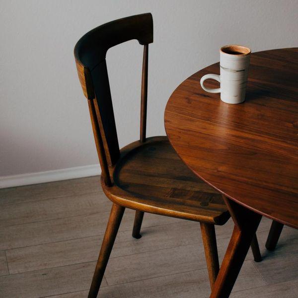 Dunkler Holzstuhl neben einem runden Tisch